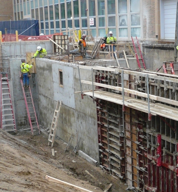 Photo of construction workers aligning steel grid